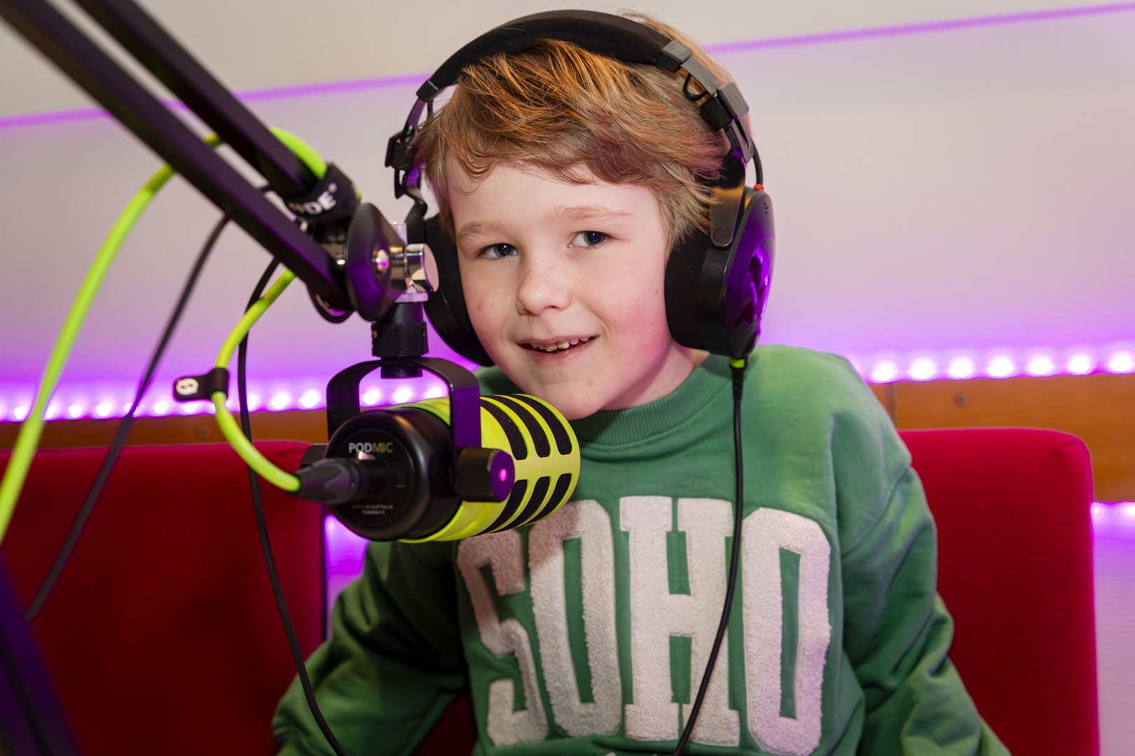 Een kind neemt een podcast op met koptelefoon en microfoon in de podcaststudio