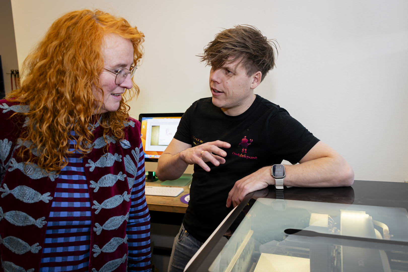 Meester Sander legt een leerkracht uit hoe de 3D-printer werkt